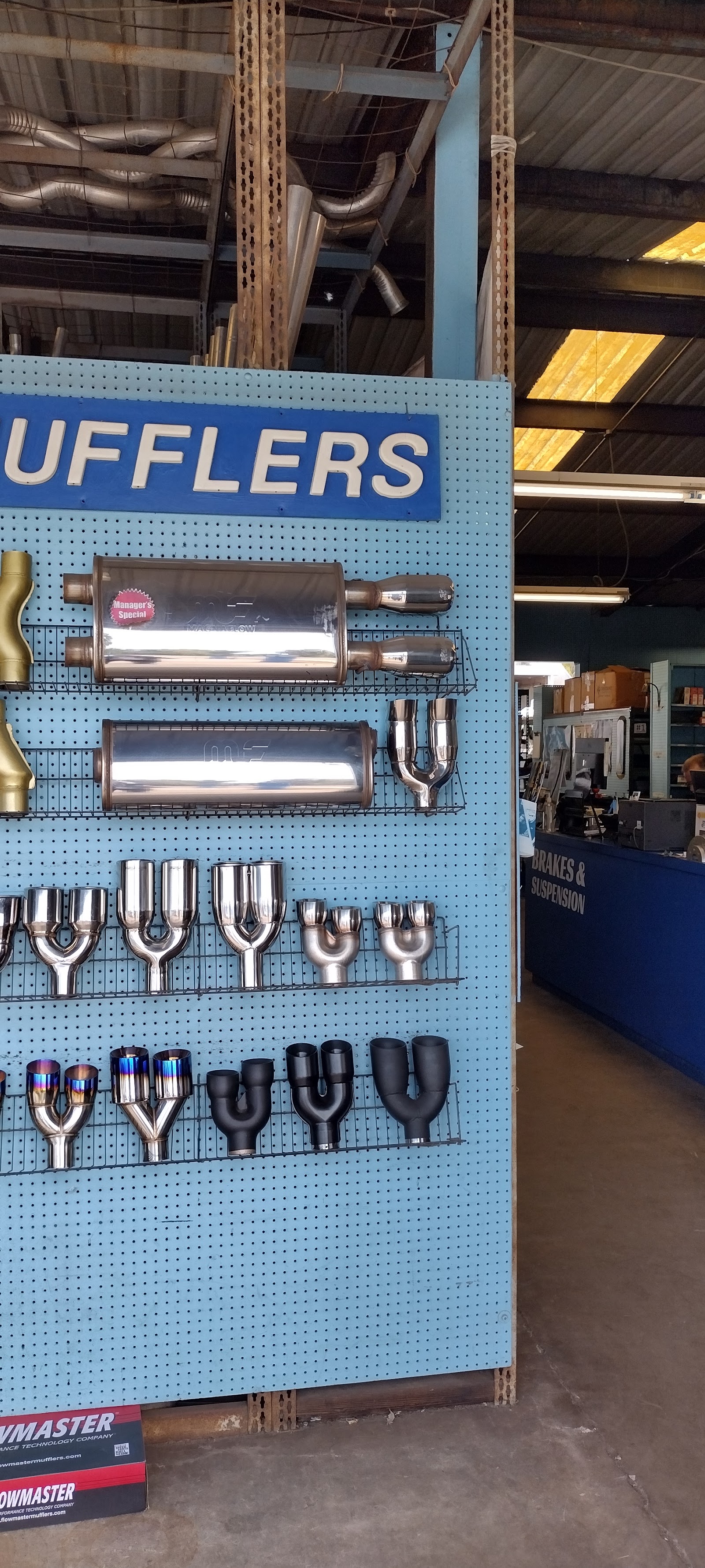 Wall display of mufflers and exhaust tips at Dualtone